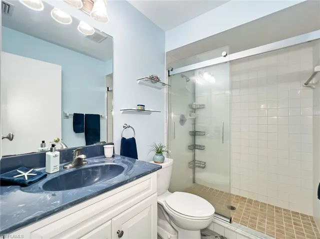 Bathroom with walk in shower, toilet, and vanity