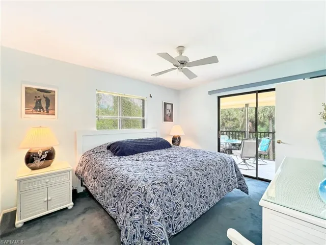 Carpeted bedroom with ceiling fan and access to outside