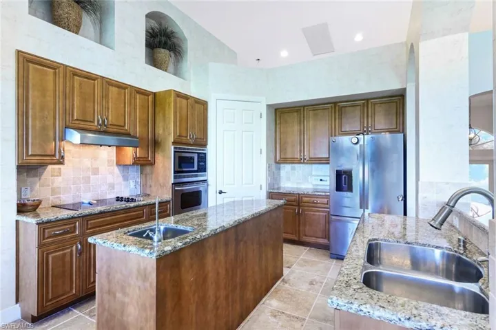 Kitchen featuring tasteful backsplash, a center island with sink, sink, and stainless steel appliances
