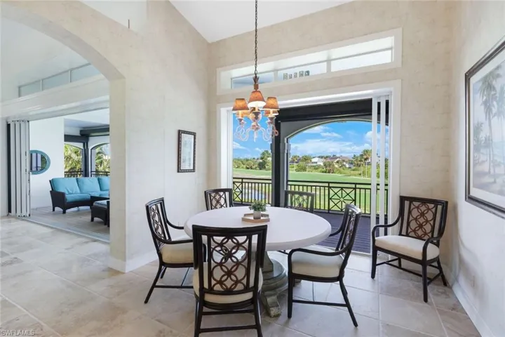 Dining space featuring tile patterned floors, a wealth of natural light, and an inviting chandelier