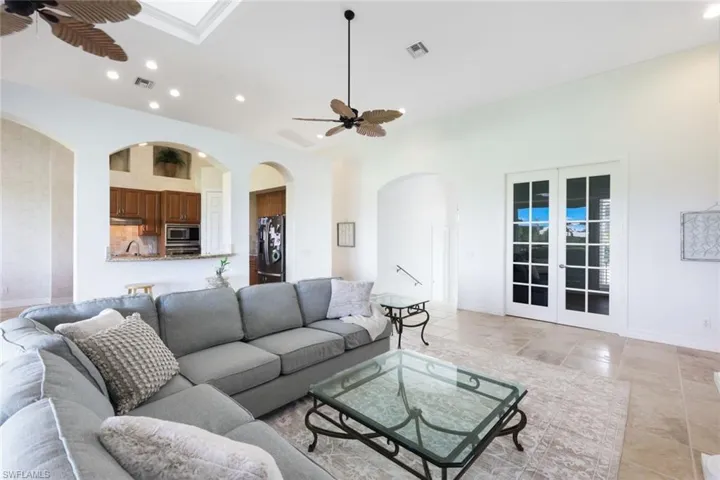 Living room featuring french doors, light tile patterned floors, and ceiling fan