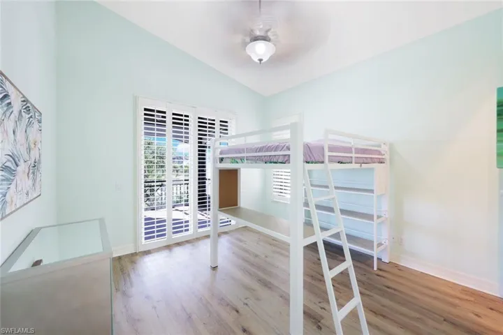Unfurnished bedroom featuring lofted ceiling, hardwood / wood-style flooring, and ceiling fan