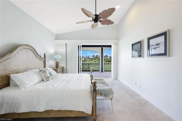 Bedroom featuring ceiling fan, access to outside, vaulted ceiling, and light tile patterned floors