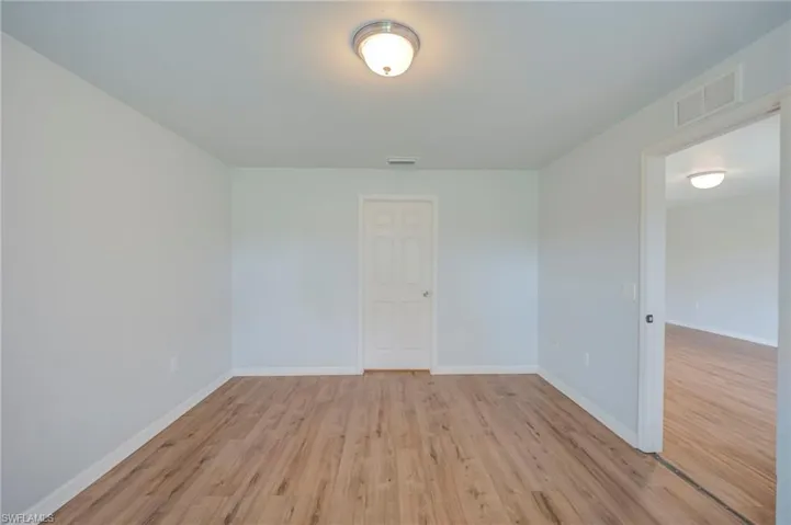 Neutral wall color, wood-finish flooring, and a central dome-style ceiling light fixture