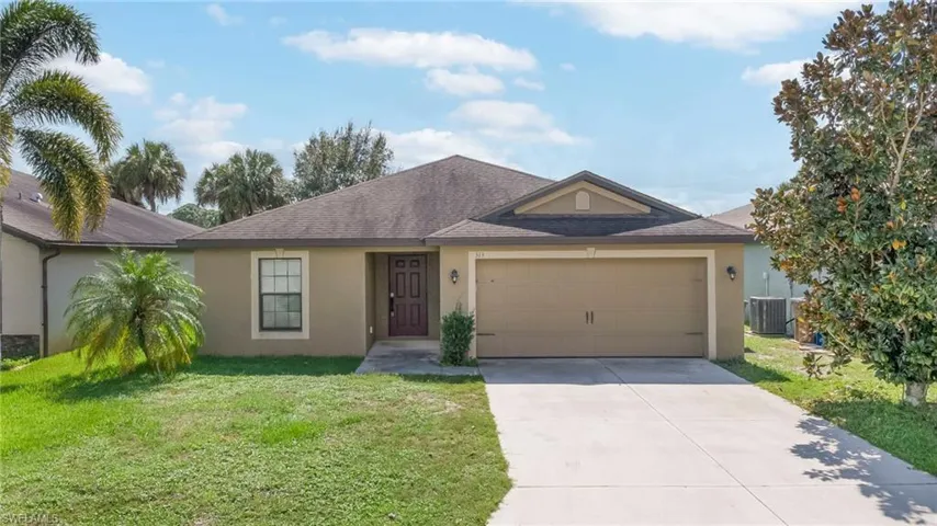 Single-story exterior featuring a neutral stucco facade, a dark-toned gable roof, an attached two-car garage, and a concrete driveway