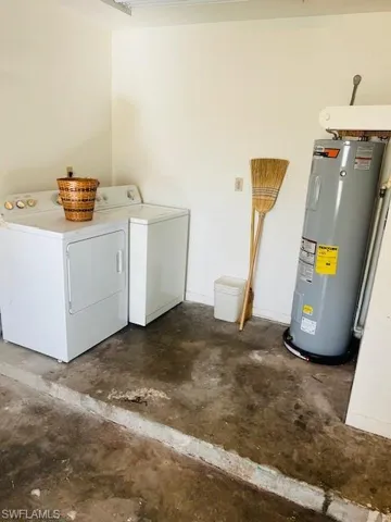 Washroom featuring electric water heater and washing machine and clothes dryer