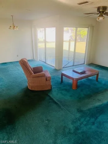 Carpeted living room featuring plenty of natural light and a textured ceiling