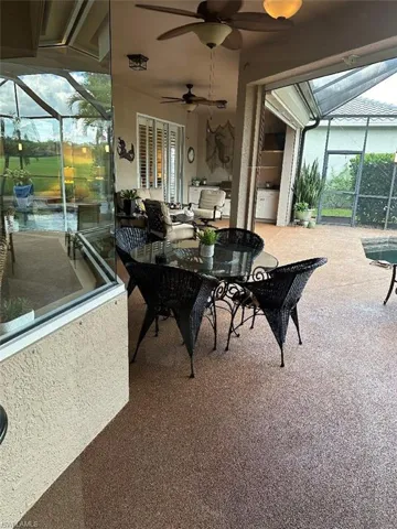 View of patio featuring glass enclosure, outdoor lounge area, and ceiling fan