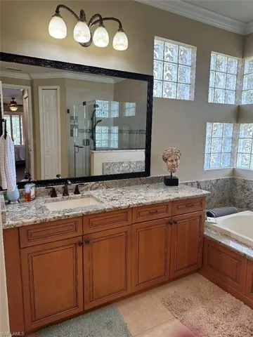 Bathroom featuring shower with separate bathtub, a wealth of natural light, ceiling fan, and vanity
