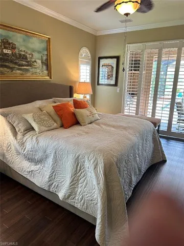 Bedroom featuring ceiling fan, access to outside, dark hardwood / wood-style floors, and crown molding