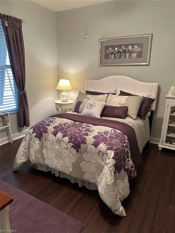 Bedroom with dark hardwood / wood-style floors
