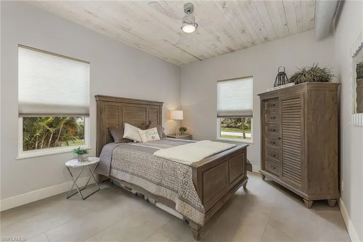 Tiled bedroom featuring wood ceiling and ceiling fan