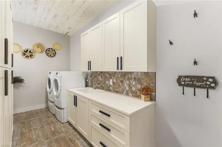 Washroom featuring sink, cabinets, washer and clothes dryer, and hardwood / wood-style flooring