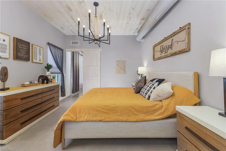 Bedroom featuring wood ceiling, a chandelier, and tile patterned flooring