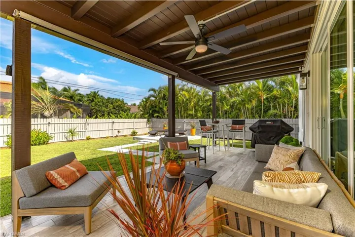 Wooden terrace with outdoor lounge area and ceiling fan
