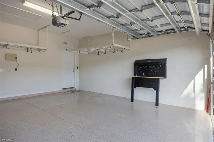 Large garage provides plenty of overhead storage racks (3) and a workbench that folds up if space is needed.