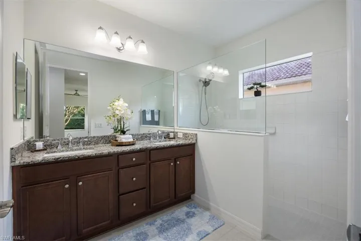 Primary bathroom with dual sinks, granite counters and walk in shower