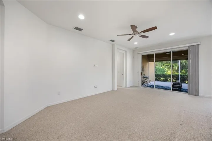 Living room overlooking the covered and screen lanai with hurricane shutter