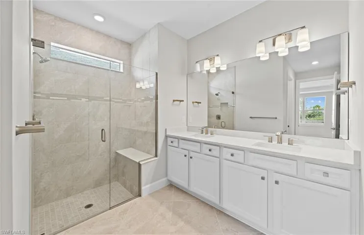 Bathroom featuring tile patterned floors, walk in shower, and vanity