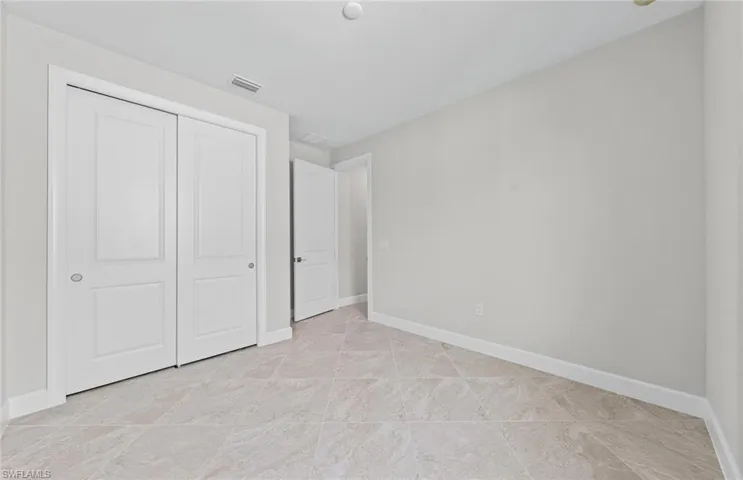 Unfurnished bedroom with a closet and light tile patterned floors