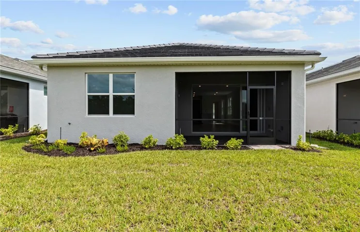 Back of property featuring a sunroom and a yard