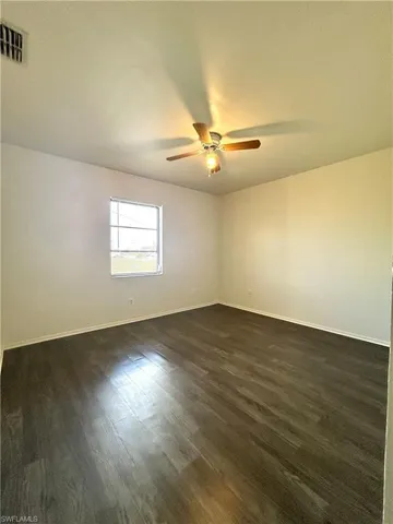 Unfurnished room with dark wood-style floors, a ceiling fan, and a textured ceiling