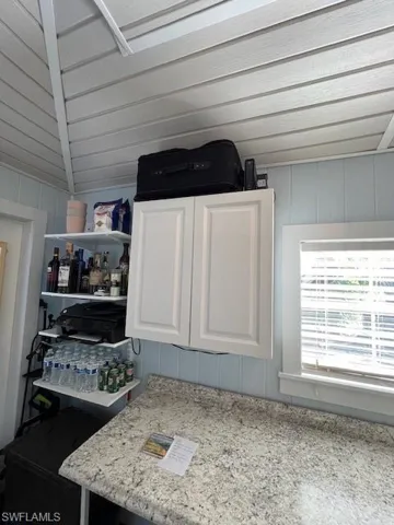 Interior details featuring white cabinetry and light stone counters