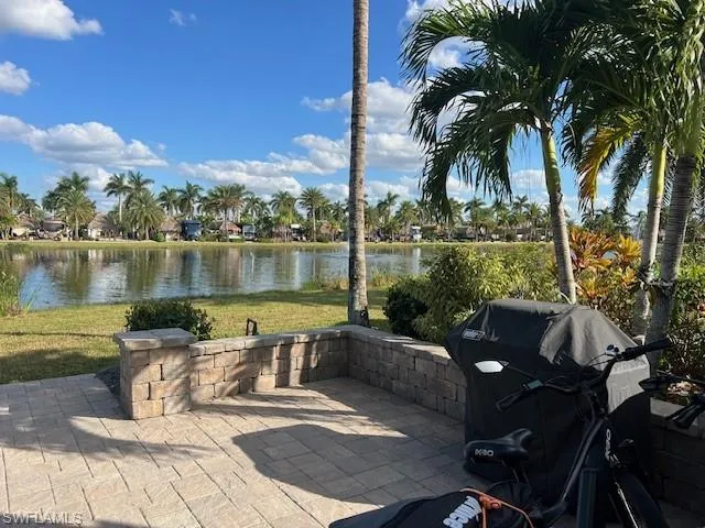 View of patio with a water view and area for grilling