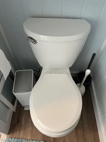 Bathroom with hardwood / wood-style flooring and toilet