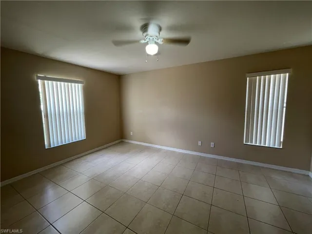 Unfurnished room with a ceiling fan and light tile patterned floors