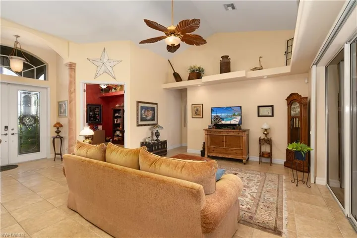 Living room featuring light tile patterned floors and high vaulted ceiling