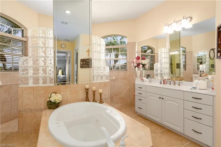 Bathroom with vanity, a washtub, and tile patterned floors