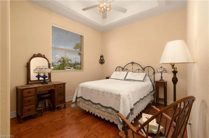 Bedroom featuring a tray ceiling, hardwood / wood-style floors, and ceiling fan