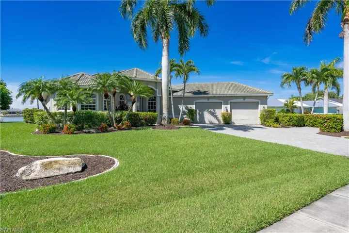 View of front of property featuring a garage and a front lawn