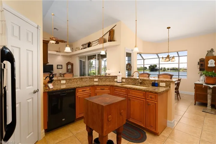 Kitchen with plenty of natural light, high vaulted ceiling, sink, and black appliances