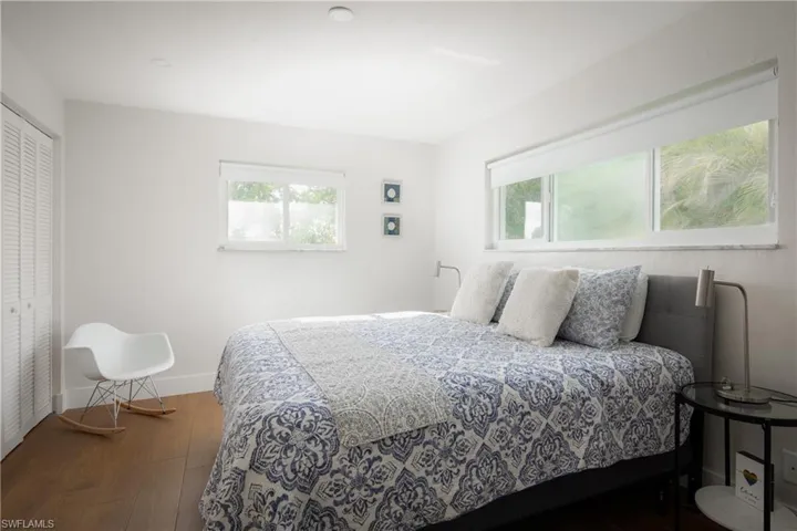 Bedroom with multiple windows, hardwood / wood-style flooring, and a closet