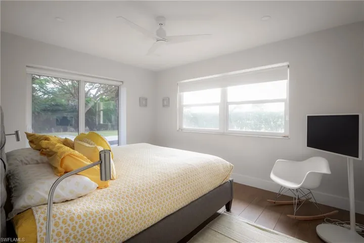 Bedroom featuring hardwood / wood-style flooring, ceiling fan, and multiple windows