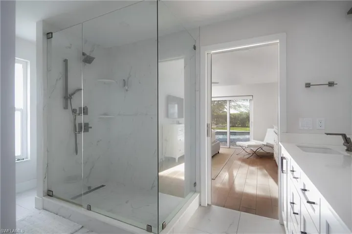 Bathroom with hardwood / wood-style flooring, a shower with shower door, and vanity