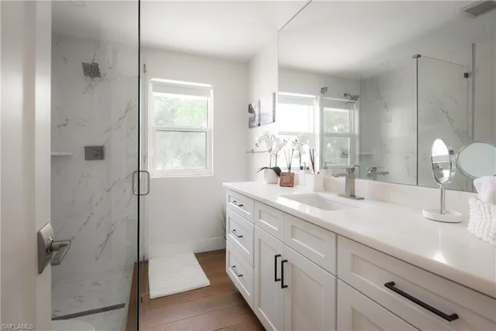 Bathroom featuring walk in shower, hardwood / wood-style floors, and vanity