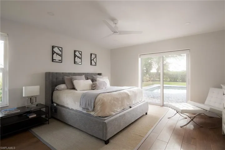 Bedroom with access to exterior, hardwood / wood-style floors, and ceiling fan