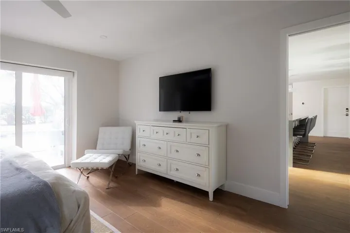 Bedroom with light wood-type flooring, access to outside, and ceiling fan