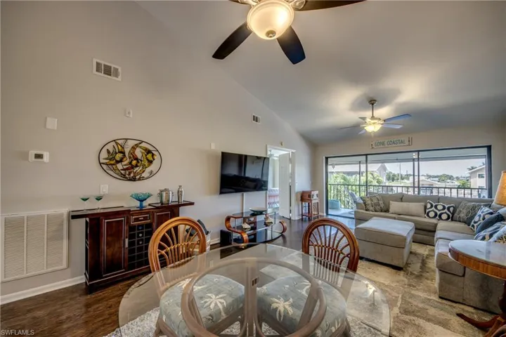 Great room with high vaulted ceiling, LVP flooring & ceiling fan
