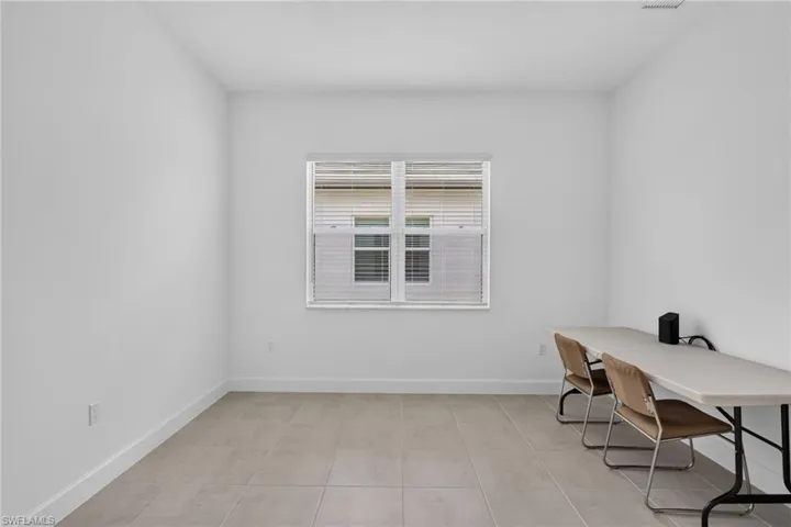 Neutral-toned ceramic tile flooring extending throughout a room featuring crisp white walls and white trim