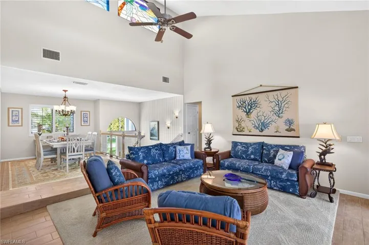 Vaulted ceilings with a stained glass accent and ceiling fan