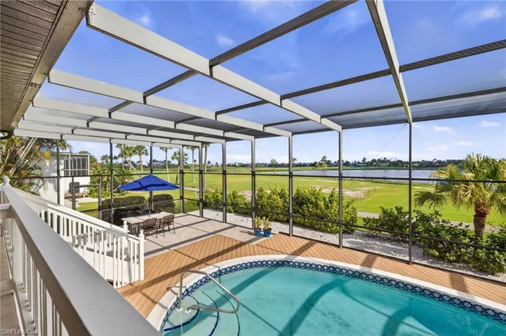 Screened lanai featuring a built-in pool, wood-finish decking, and a paved patio area