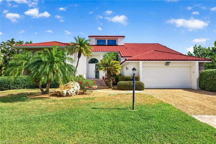 Mediterranean-style residence featuring a red tile roof and a white stucco exterior