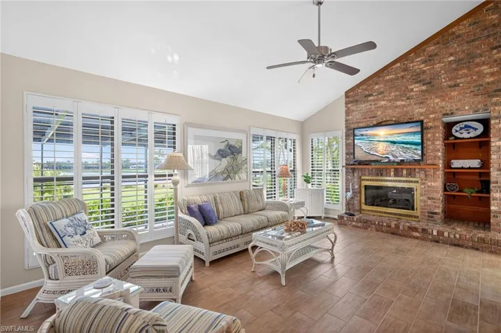 Spacious living area featuring a vaulted ceiling and a ceiling fan