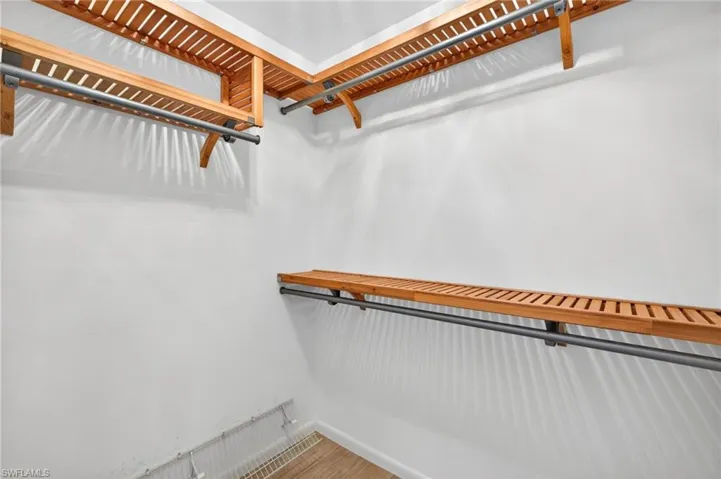 Custom wood-slat shelving system featuring metal hanging rods