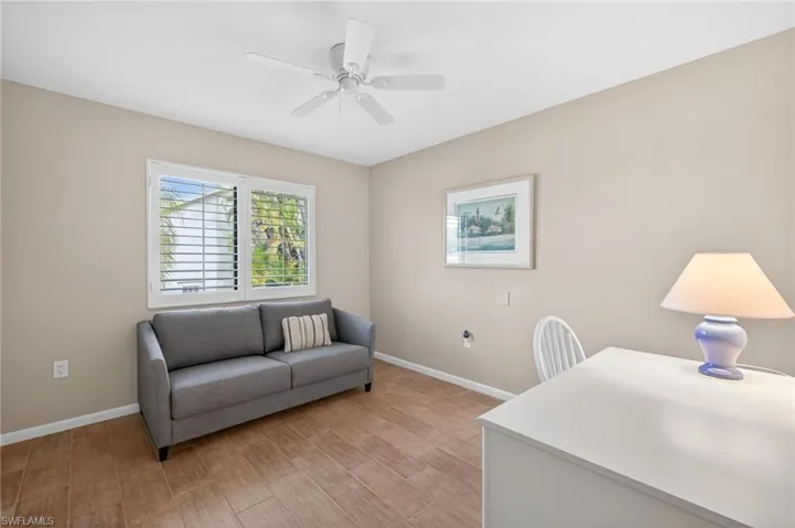 Room featuring wood-look tile flooring, neutral wall paint, and a ceiling fan