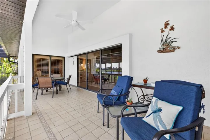 Expansive covered patio featuring tiled flooring, a high vaulted ceiling, and an overhead ceiling fan